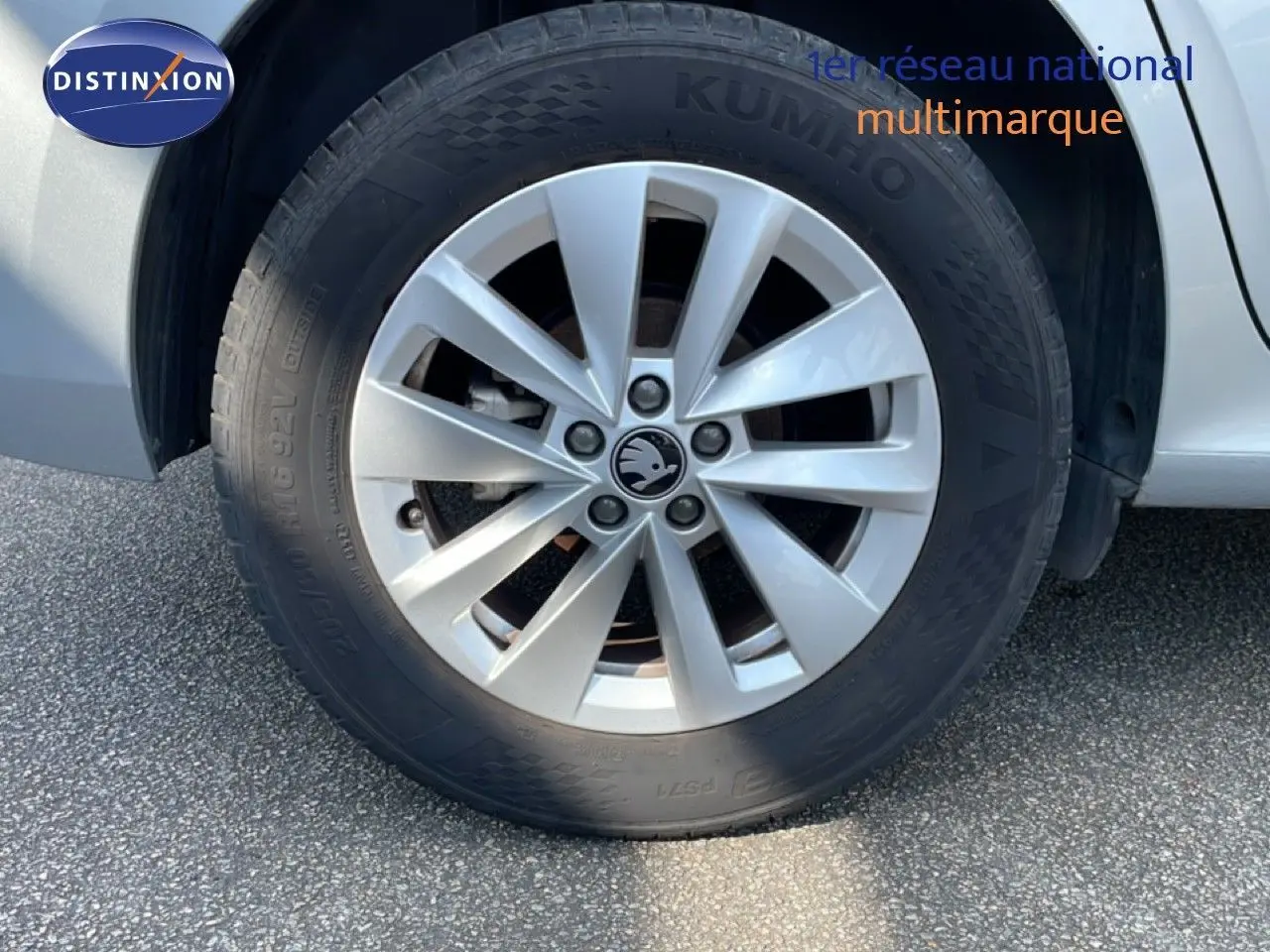 Gros plan sur la roue avant droite gris argent métallisé d’un Skoda Kamiq 2025 avec jante alliage et logo central visible.