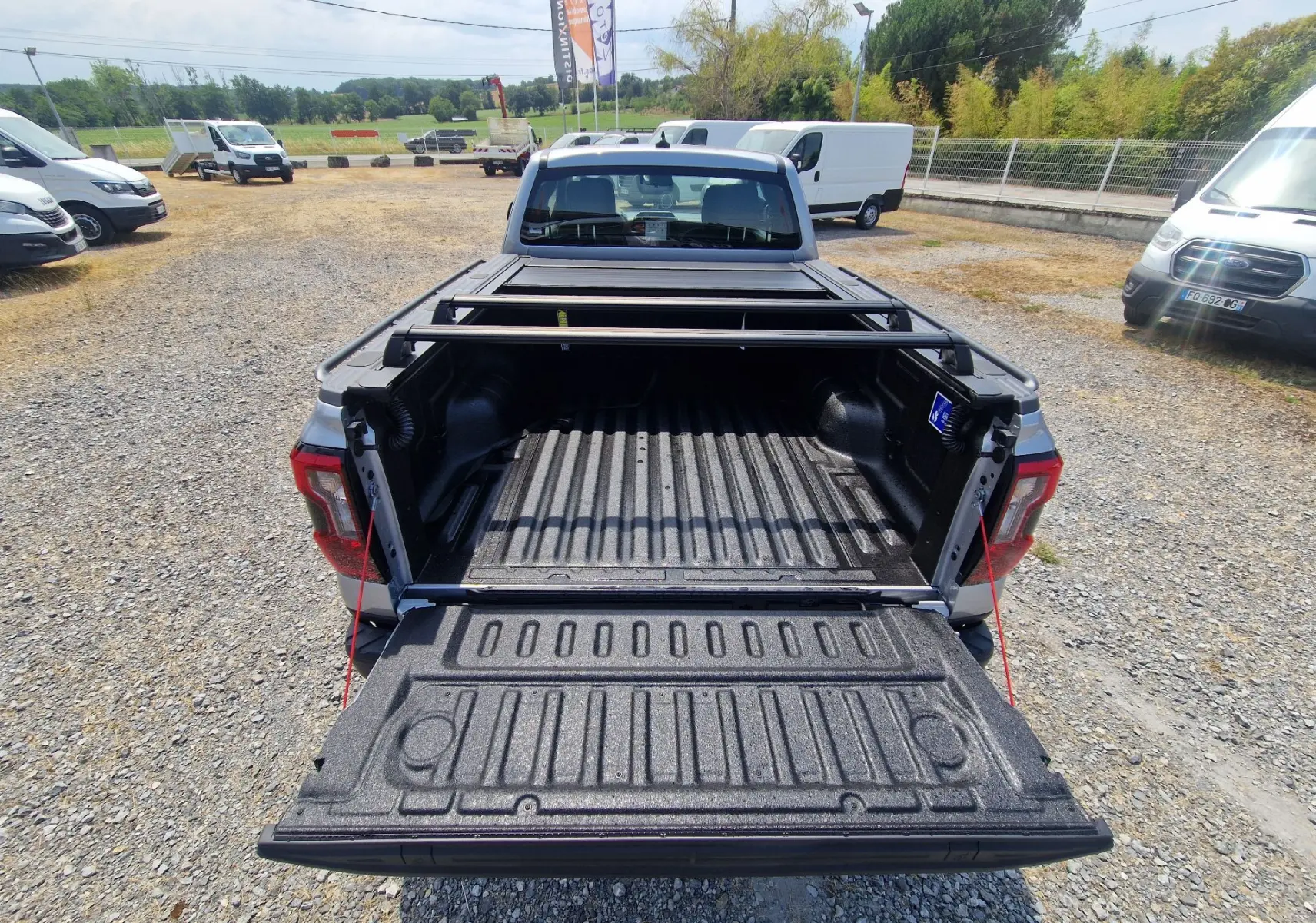Vue arrière plongeante du Ford Ranger Super Cabine gris Iconic avec plateau ouvert et barres de renfort visibles.