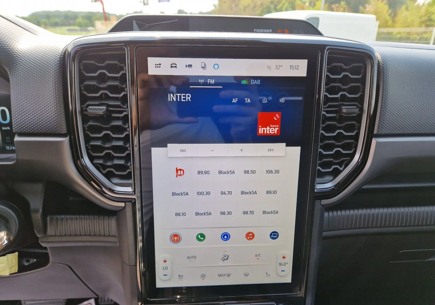 Vue intérieure centrée sur l’écran tactile 12,4’’ du Ford Ranger Super Cabine gris Iconic, avec commandes climatisation visibles.