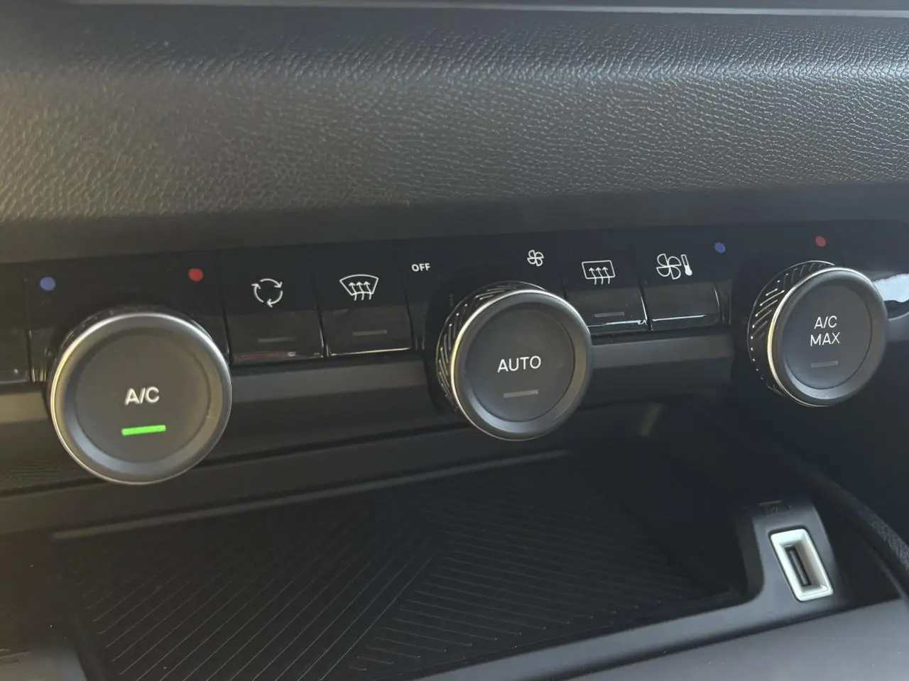 Gros plan sur les commandes de climatisation automatique de la Citroën C4 Hybrid 145 gris Mercury, avec boutons rotatifs et affichages.