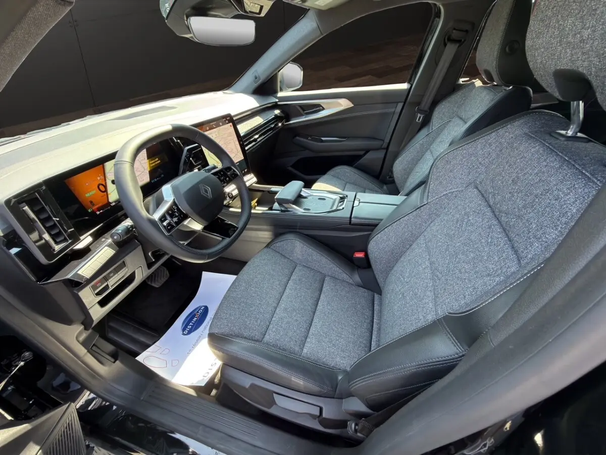 Intérieur avant droit de la Renault Rafale 2025 noir, sièges tissu gris, tableau de bord avec écran tactile vertical.