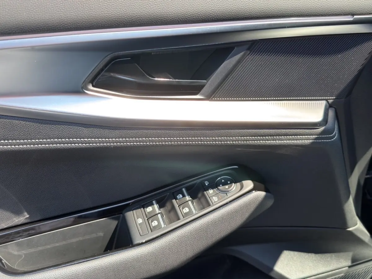 Détail de la porte côté conducteur noire du Renault Rafale 2025 avec commandes des vitres et rétroviseurs.