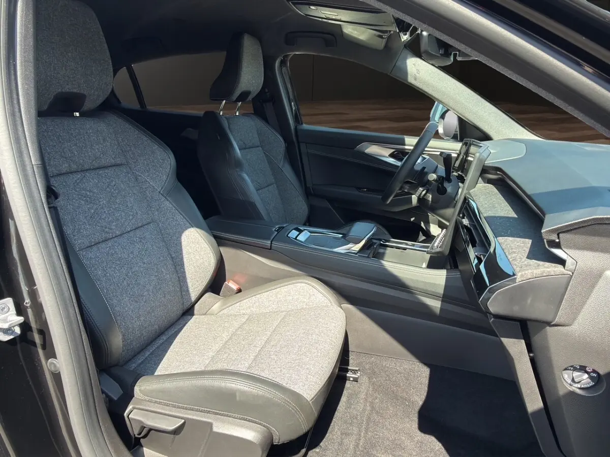 Vue intérieure côté conducteur de la Renault Rafale 2025 noire, sièges tissu gris avec surpiqûres et tableau de bord moderne.