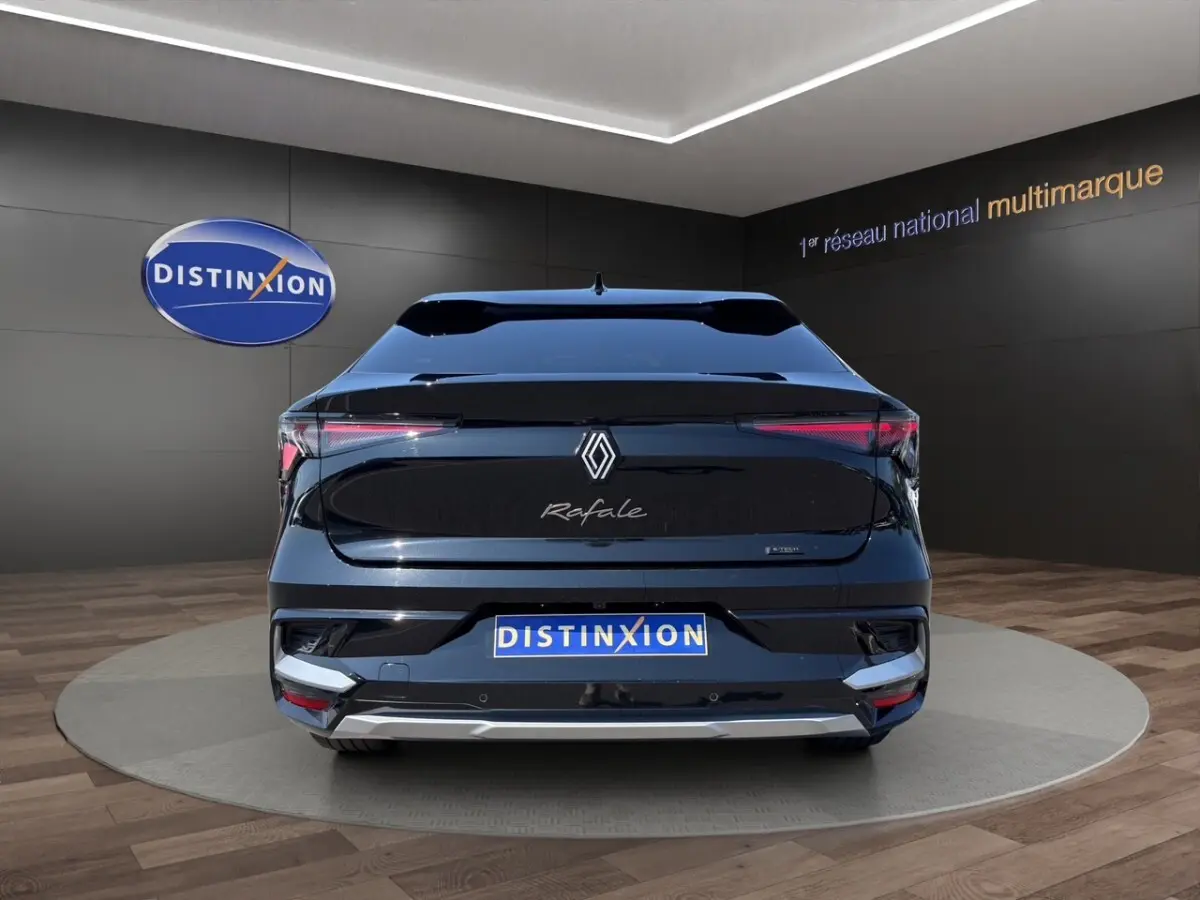 Vue arrière noire du Renault Rafale 2025 avec feux LED fins et logo distinctif sur fond showroom.