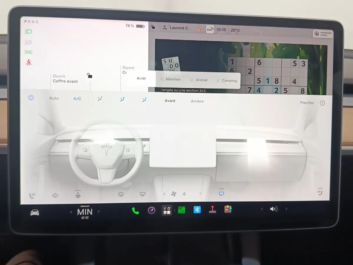 Écran tactile central de la Tesla Model 3 blanche 2022, affichant tableau de bord et commandes climatisation.
