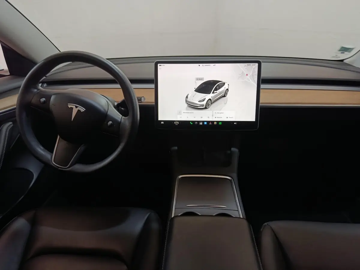 Vue intérieure frontale du tableau de bord noir avec écran tactile central et volant Tesla Model 3 Grande Autonomie 2022.