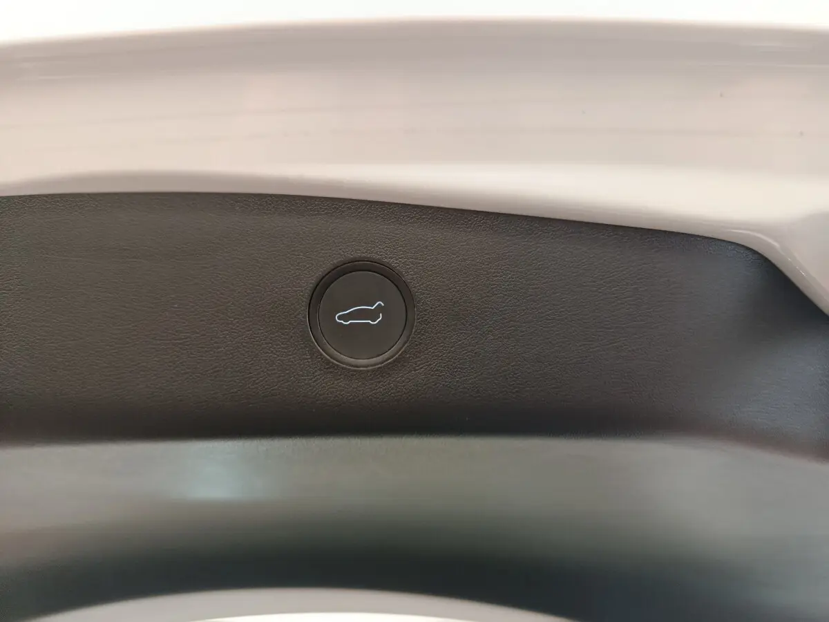 Bouton d'ouverture du coffre sur la garniture intérieure arrière d'une Tesla Model 3 blanche 2022.