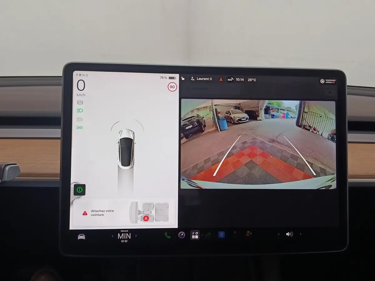 Écran central tactile de Tesla Model 3 blanc 2022 montrant la caméra de recul et l'affichage de conduite.