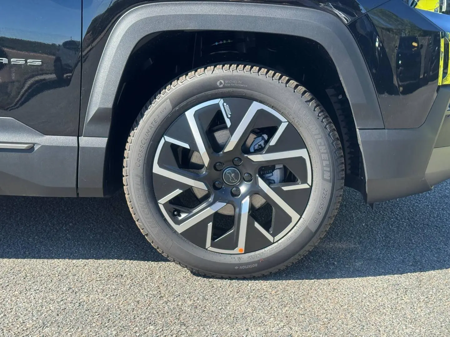 Gros plan sur la roue avant droite du Jeep Compass Yosemite noir, mettant en valeur la jante alu au design moderne.
