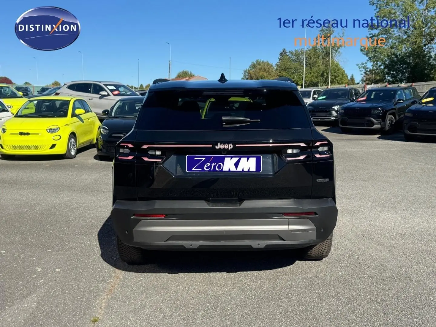 Vue arrière d'un Jeep Compass 2026 noir avec toit noir, stationné sur un parking en plein jour.