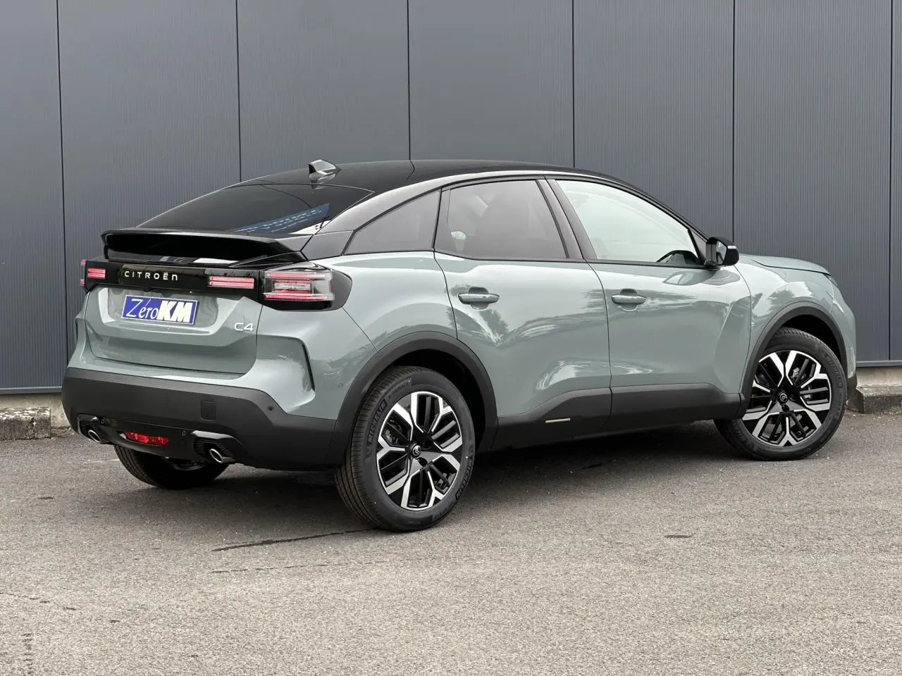 Vue 3/4 arrière droite d'une Citroën C4 Manhattan Green avec toit noir et jantes alliage 18 pouces.