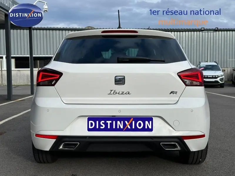 Vue arrière d'une SEAT Ibiza 1.0 TSI FR blanche Nevada métal avec feux LED et double sortie d'échappement intégrée.