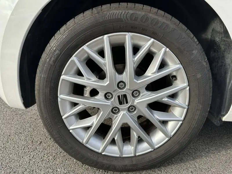 Gros plan sur la roue avant gauche d'une SEAT Ibiza 2025 blanc Nevada métal avec jante alliage argentée à multiples branches.