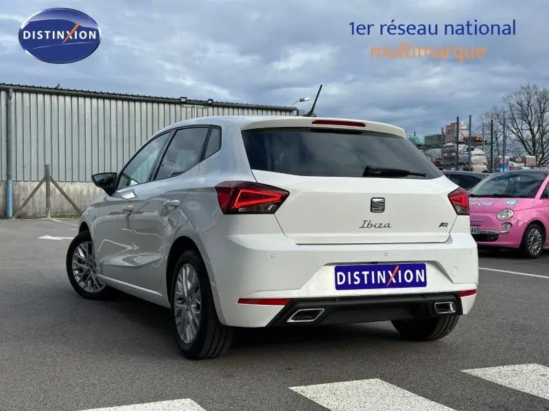 Vue 3/4 arrière droite d'une SEAT Ibiza 1.0 TSI 115cv FR blanche Nevada métal avec feux arrière LED et double sortie d'échappement.