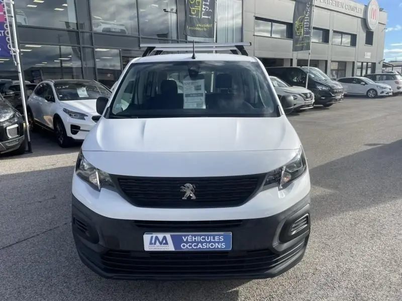 Vue de face d'un Peugeot Rifter blanc 2020 avec calandre noire et plaque "Véhicules Occasions" en concession.