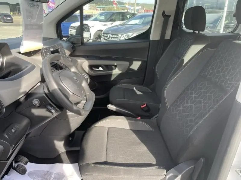 Vue intérieure côté conducteur du Peugeot Rifter blanc 2020, mettant en valeur les sièges et le volant.
