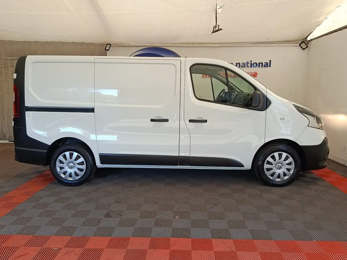 Profil droit du Renault Trafic Fourgon blanc de 2017 avec portes latérales pleines et jantes acier.