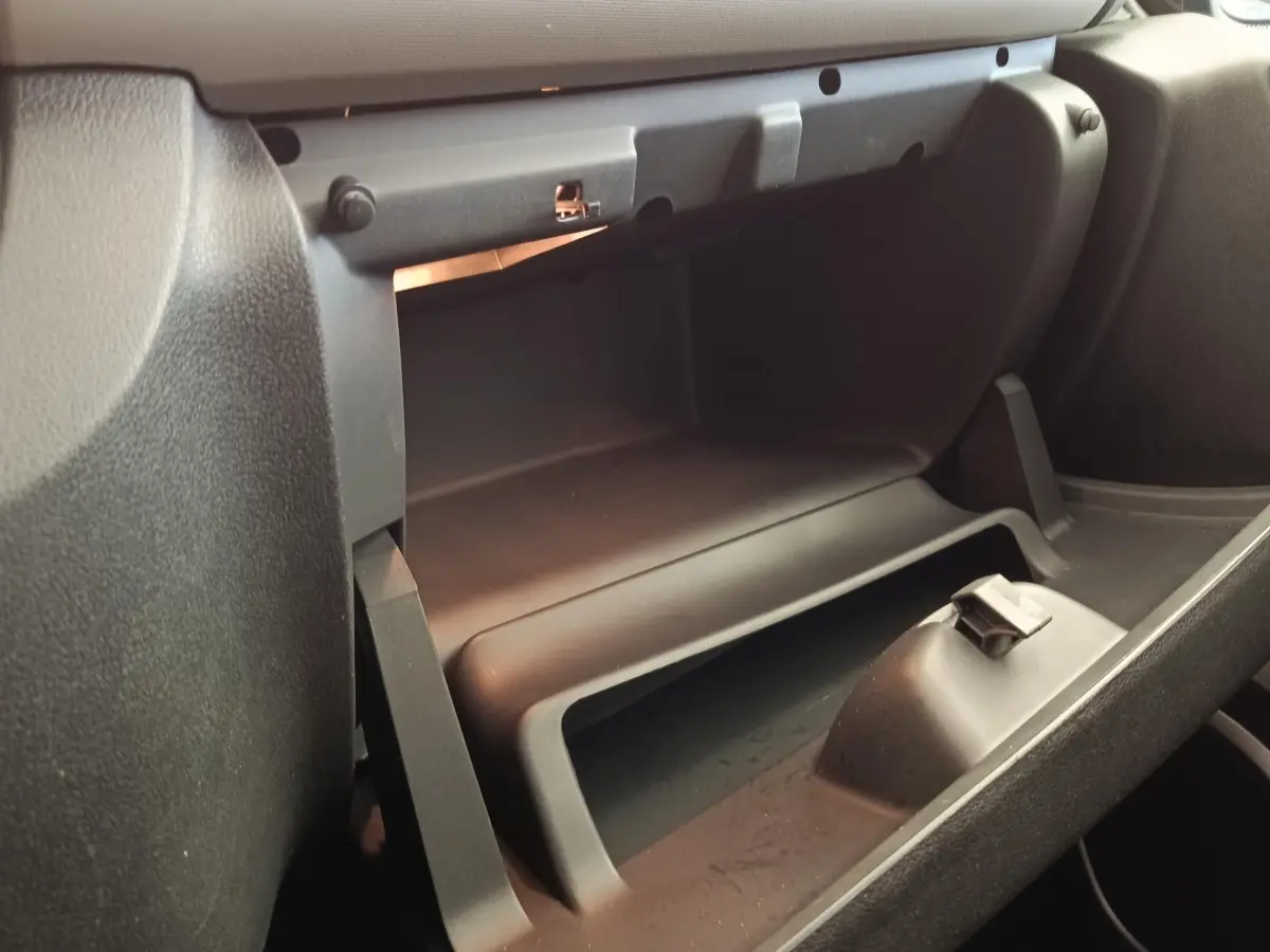 Intérieur du Renault Trafic Fourgon 2017, vue rapprochée de la boîte à gants ouverte côté passager, plastique noir mat.