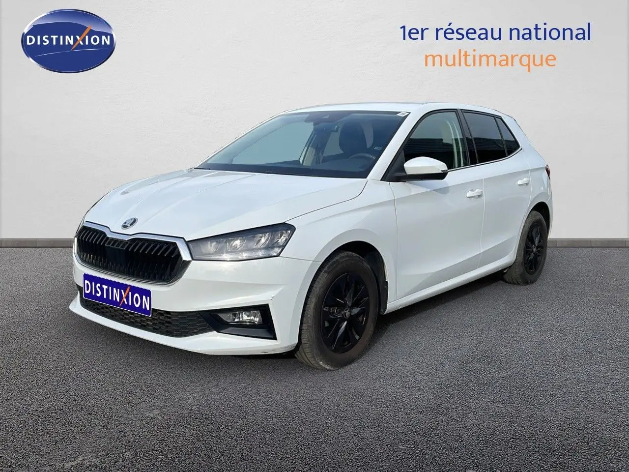 Vue 3/4 avant droite d'une Skoda Fabia blanche glacier avec jantes noires et calandre noire distinctive.