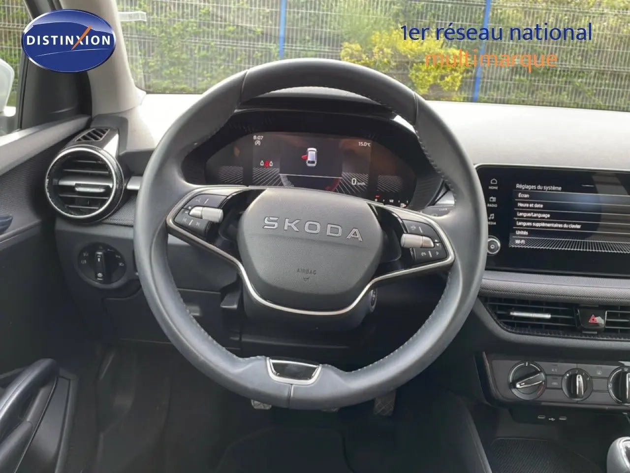 Vue intérieure centrée sur le volant cuir noir SKODA Fabia 2025 avec tableau de bord digital et écran tactile.