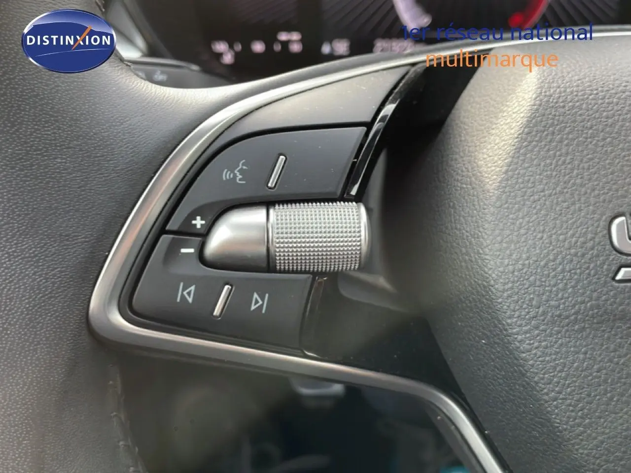 Gros plan sur les commandes multifonctions à gauche du volant cuir d'une Skoda Fabia blanc glacier 2025.