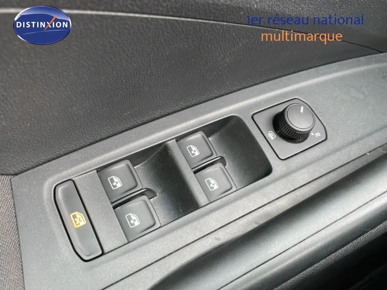 Gros plan sur les commandes de lève-vitres et réglage des rétroviseurs côté conducteur d'une Skoda Fabia blanche Glacier 2025.