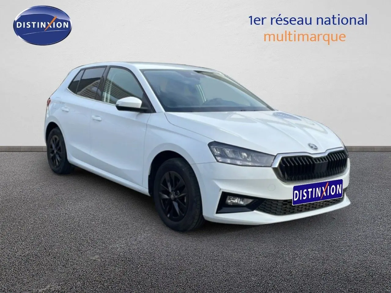 Vue 3/4 avant droite d'une Skoda Fabia blanc glacier avec jantes noires et calandre noire distinctive.