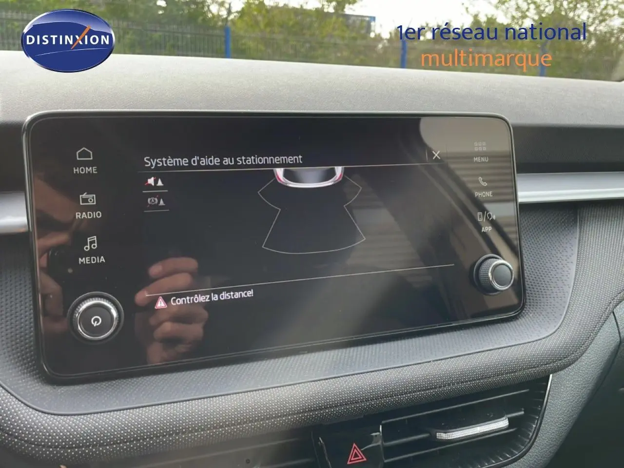 Écran tactile du système d'aide au stationnement dans l'habitacle d'une Skoda Fabia blanc glacier, vue de face.