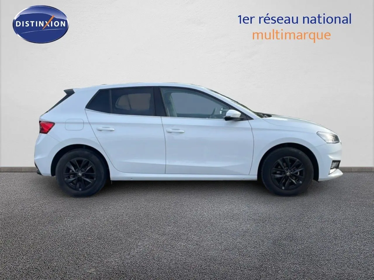 Vue de profil côté gauche d'une Skoda Fabia blanche glacier avec jantes noires sur fond neutre.