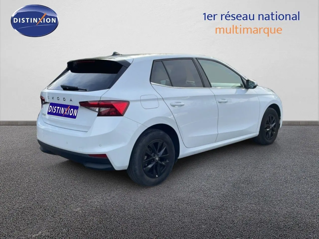 Vue 3/4 arrière droite d'une Skoda Fabia blanc glacier avec jantes noires et vitres teintées.