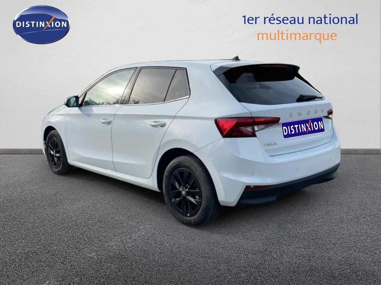 Vue 3/4 arrière droite d'une Skoda Fabia blanche glacier avec jantes noires et vitres teintées.