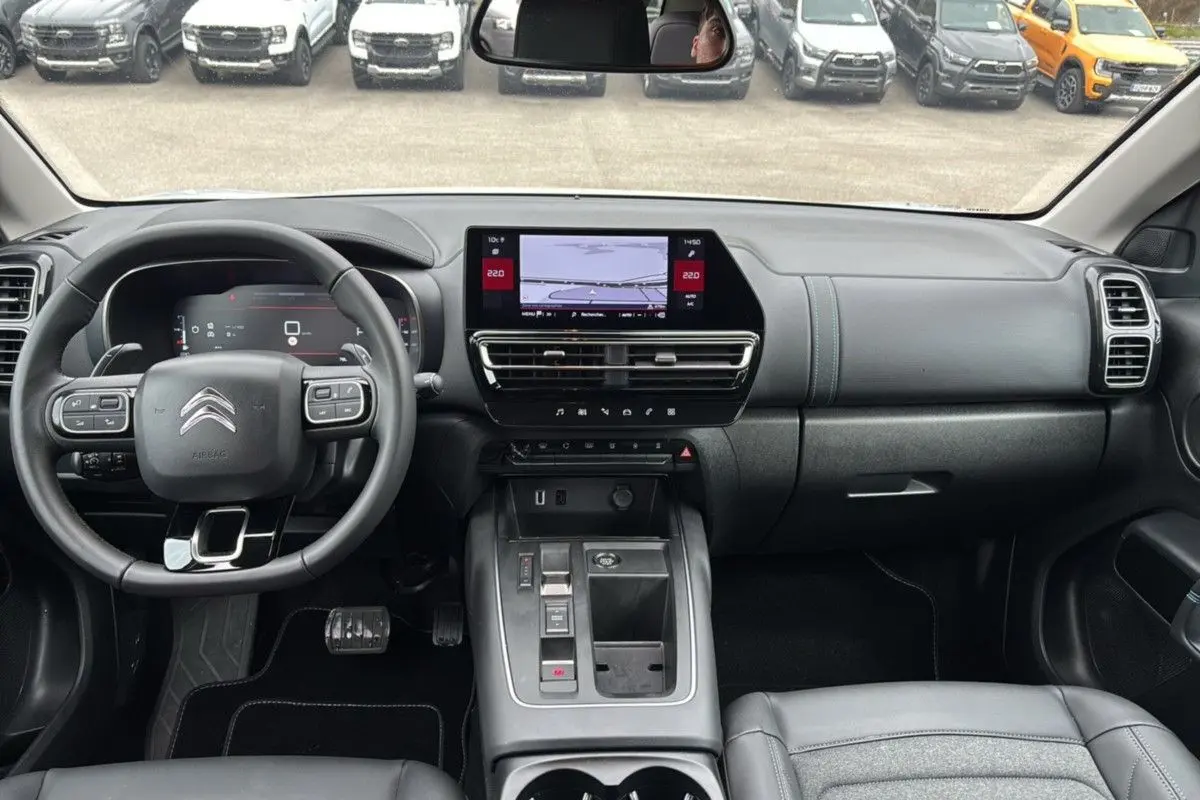 Vue intérieure avant du Citroën C5 Aircross Hybrid blanc, tableau de bord moderne avec écran tactile central.