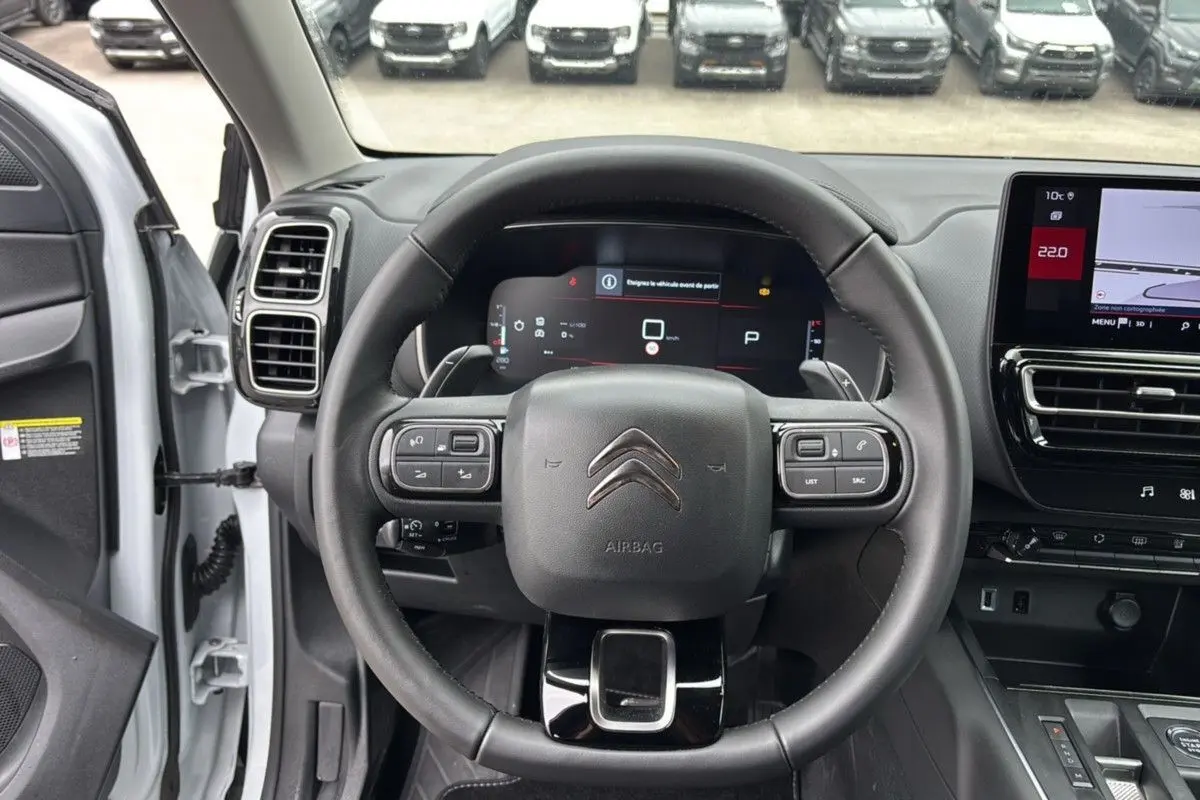 Vue intérieure centrée sur le volant du Citroën C5 Aircross blanc Okenite, avec tableau de bord numérique et écran tactile.