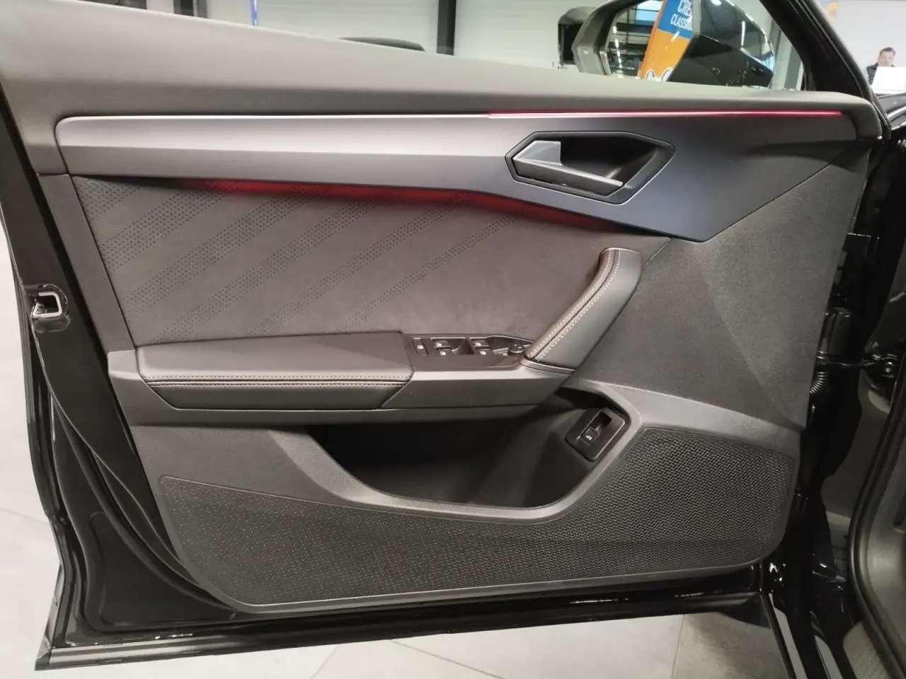Contre-porte côté gauche noir suédine avec surpiqûres cuivrées et bandeau lumineux rouge du CUPRA Formentor 2026.