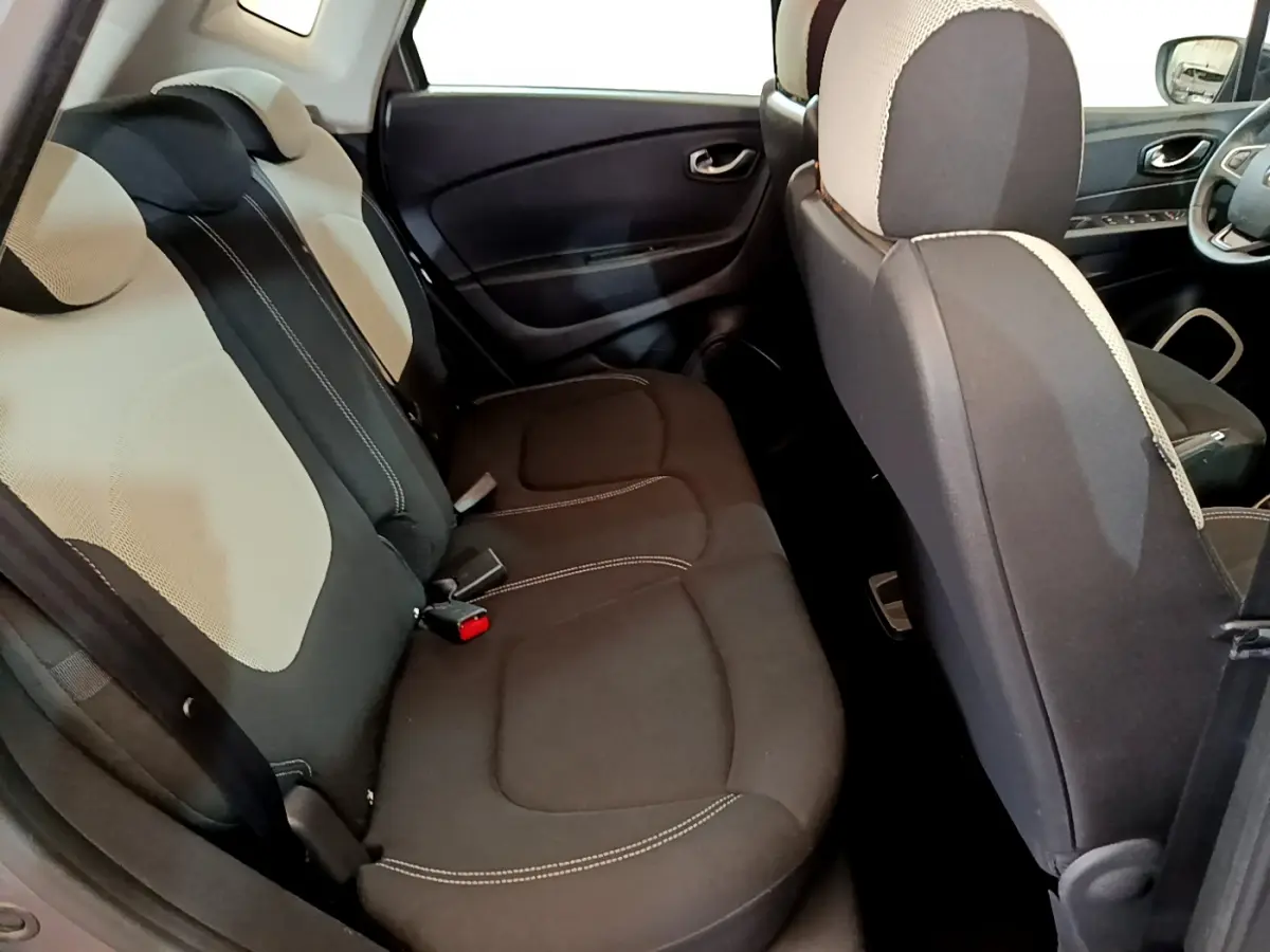 Vue intérieure côté arrière droit du Renault Captur 2018, sièges tissu bicolore gris clair et foncé.
