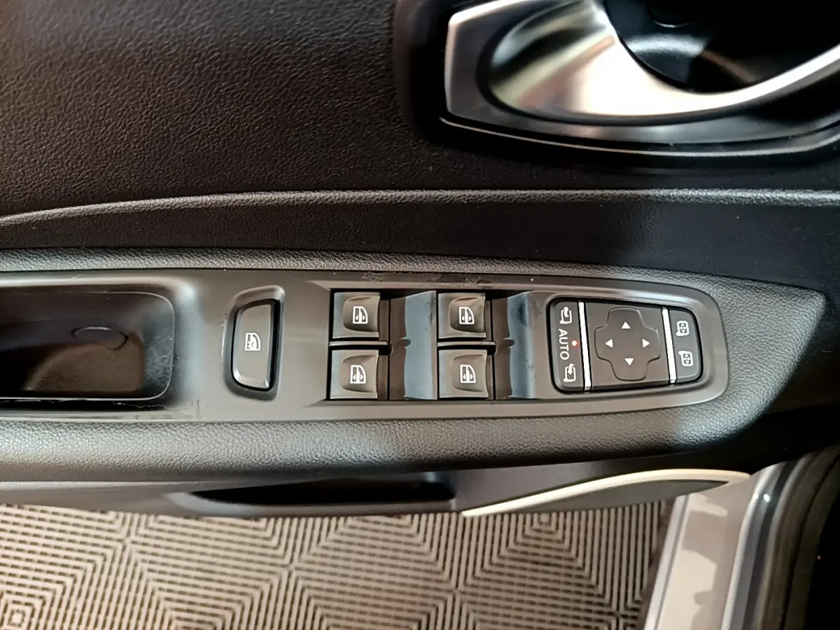 Vue rapprochée des commandes de lève-vitres et rétroviseurs sur la porte côté conducteur d'un Renault Captur gris foncé 2018.