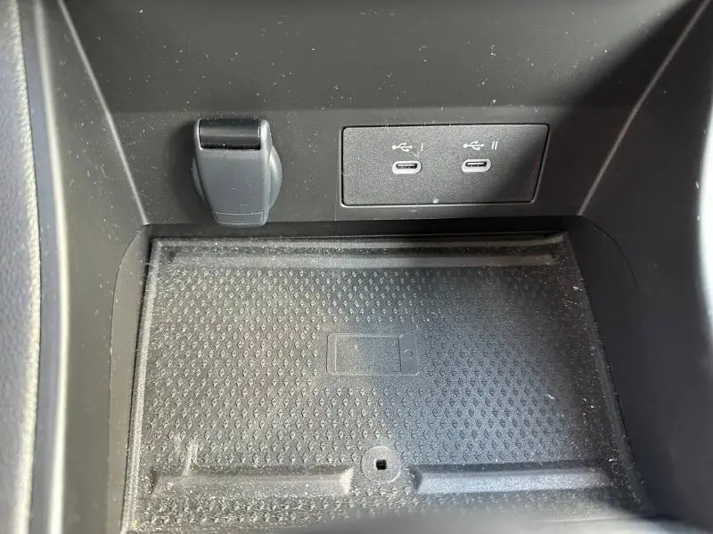 Gros plan sur la zone de recharge sans fil et les deux ports USB-C du Renault Captur rouge 2025, version Techno.