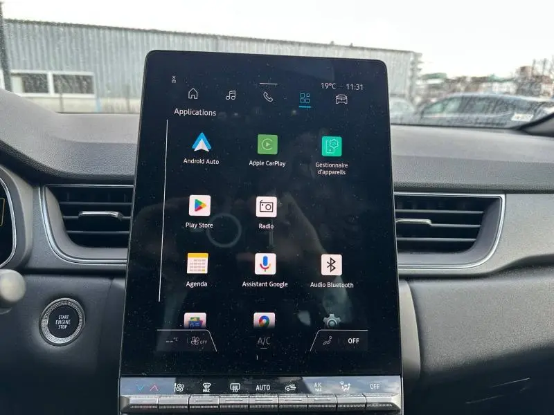 Écran tactile central du tableau de bord du Renault Captur rouge, affichant les applications connectées.