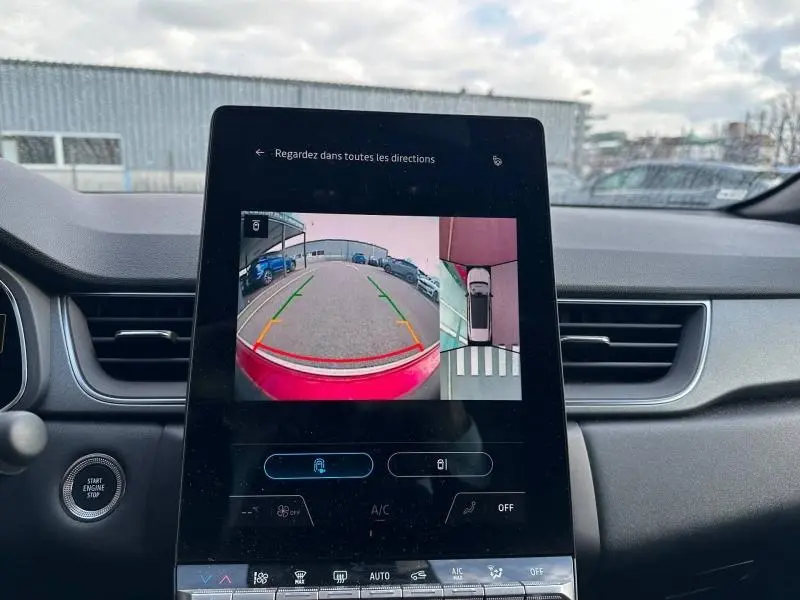Vue intérieure du tableau de bord du Renault Captur rouge 2025, écran tactile affichant la caméra de recul et vue à 360°.