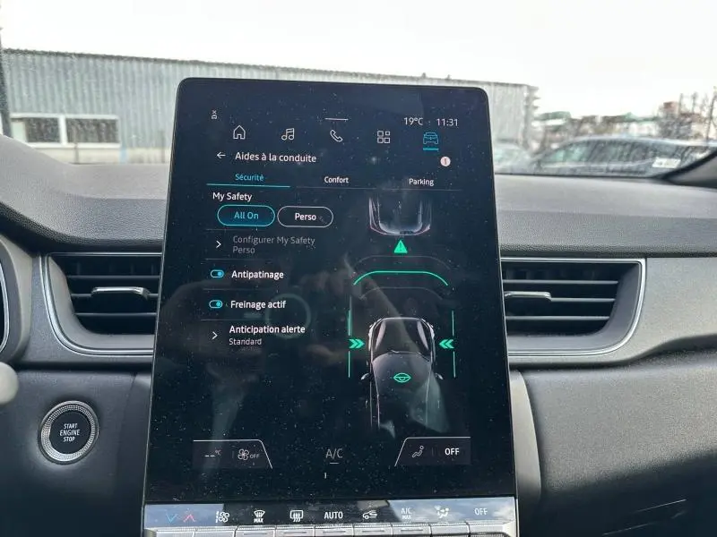 Vue intérieure du tableau de bord du Renault Captur 2025, écran tactile central affichant les aides à la conduite.