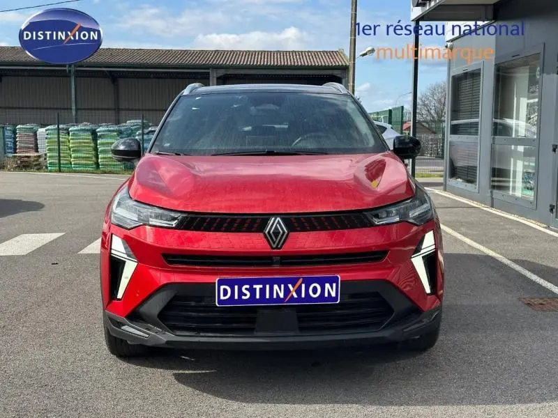 Vue de face d'un Renault Captur rouge flamme 2025 avec calandre noire et feux LED verticaux distinctifs.
