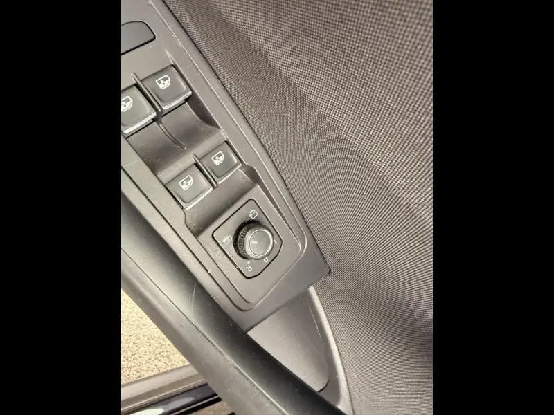 Gros plan sur les commandes de réglage des rétroviseurs et des vitres côté conducteur du Volkswagen T-Roc Cabriolet noir métal 2020.