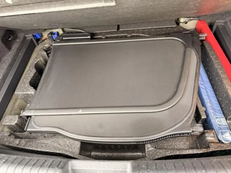 Détail du coffre du Volkswagen T-Roc Cabriolet noir métal 2020, montrant le rangement du cache-bagages replié.