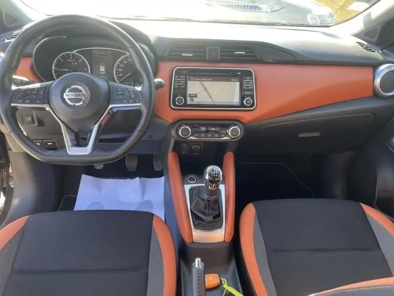 Vue intérieure avant de la Nissan Micra 1.5 DCI 90 N-Connecta 2017, tableau de bord noir et orange avec boîte manuelle.