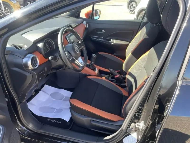 Intérieur côté conducteur de la Nissan Micra 1.5 DCI 90 N-Connecta 2017 noir, avec sièges noirs et orange et boîte manuelle.