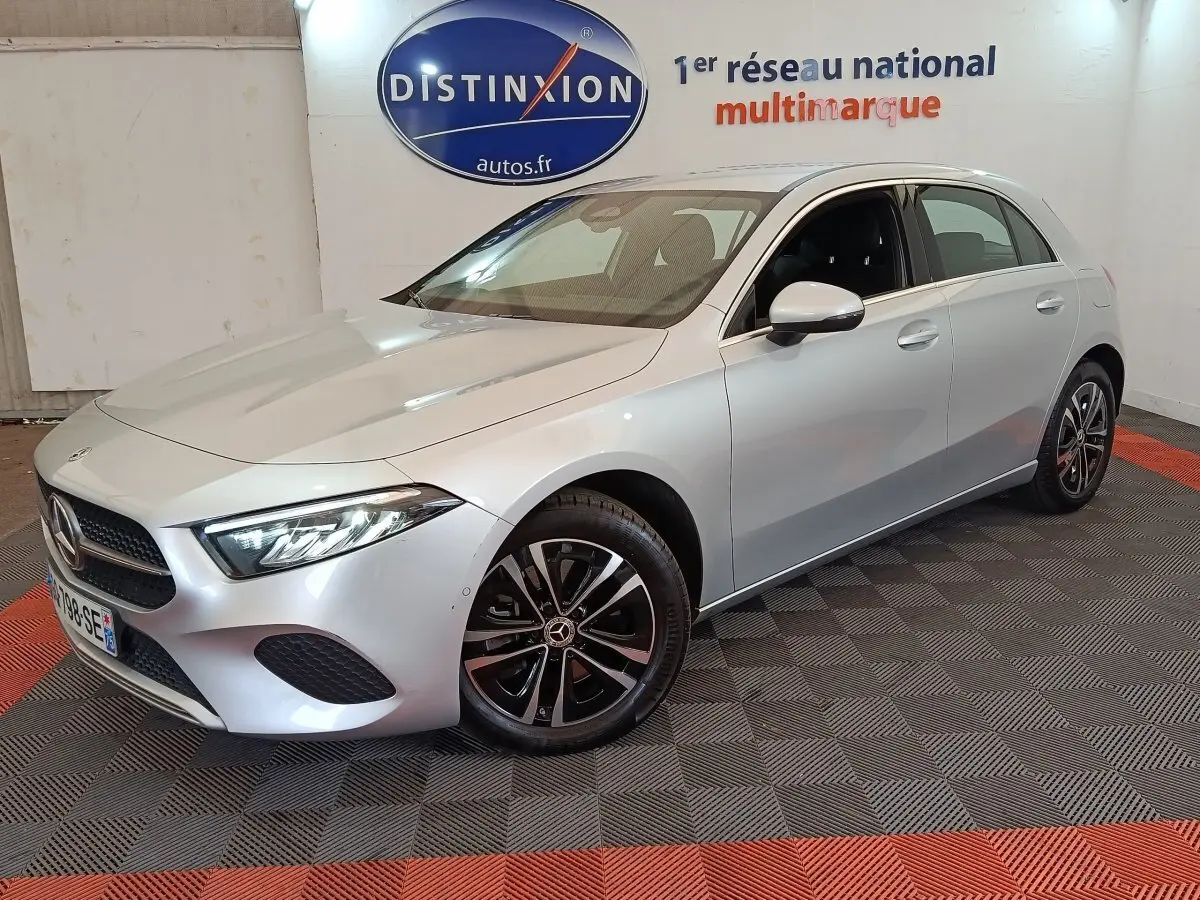 Mercedes GLA 250 e Business Line gris clair vue 3/4 avant droit en intérieur sur sol damier noir et rouge.