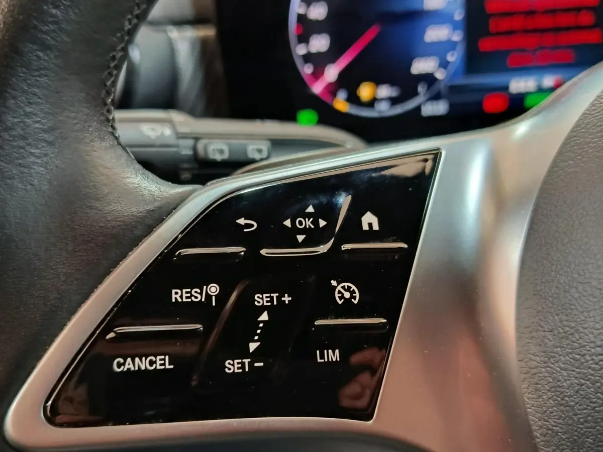 Gros plan sur les commandes du volant cuir à gauche du Mercedes GLA 250 e Business Line gris foncé 2023.