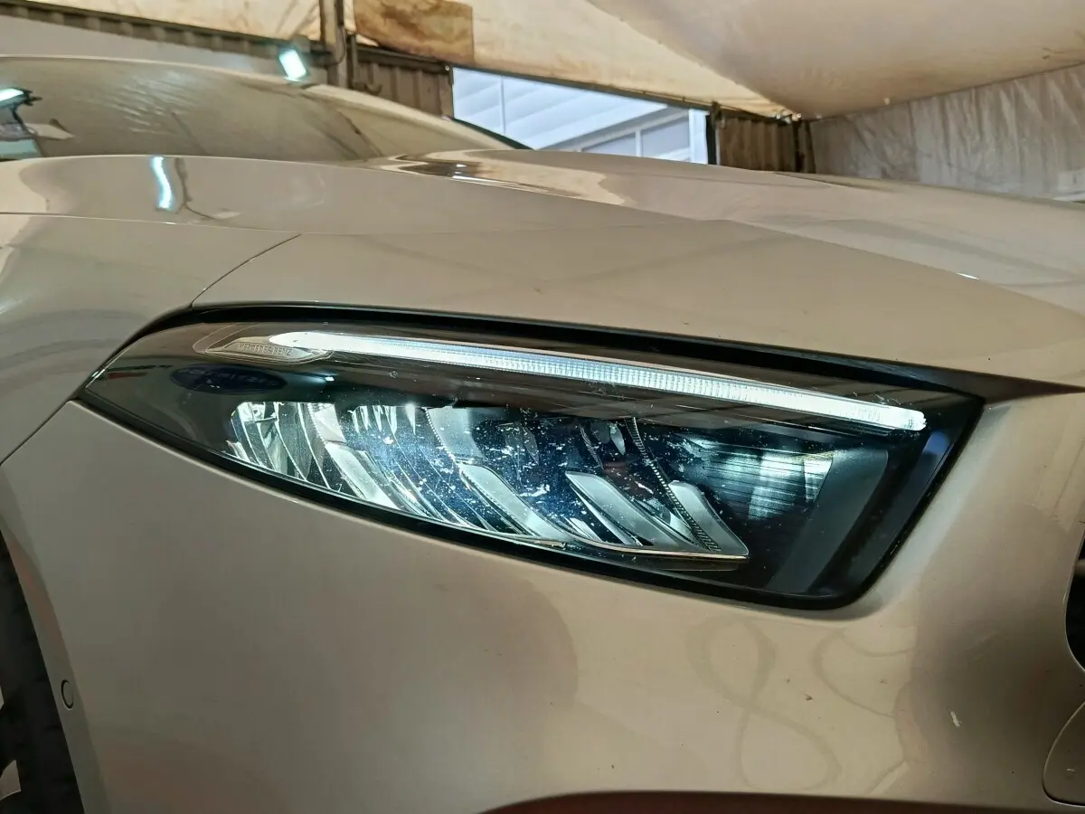 Gros plan sur le phare avant droit gris foncé du Mercedes GLA 250 e Business Line 2023 avec LED distinctive.