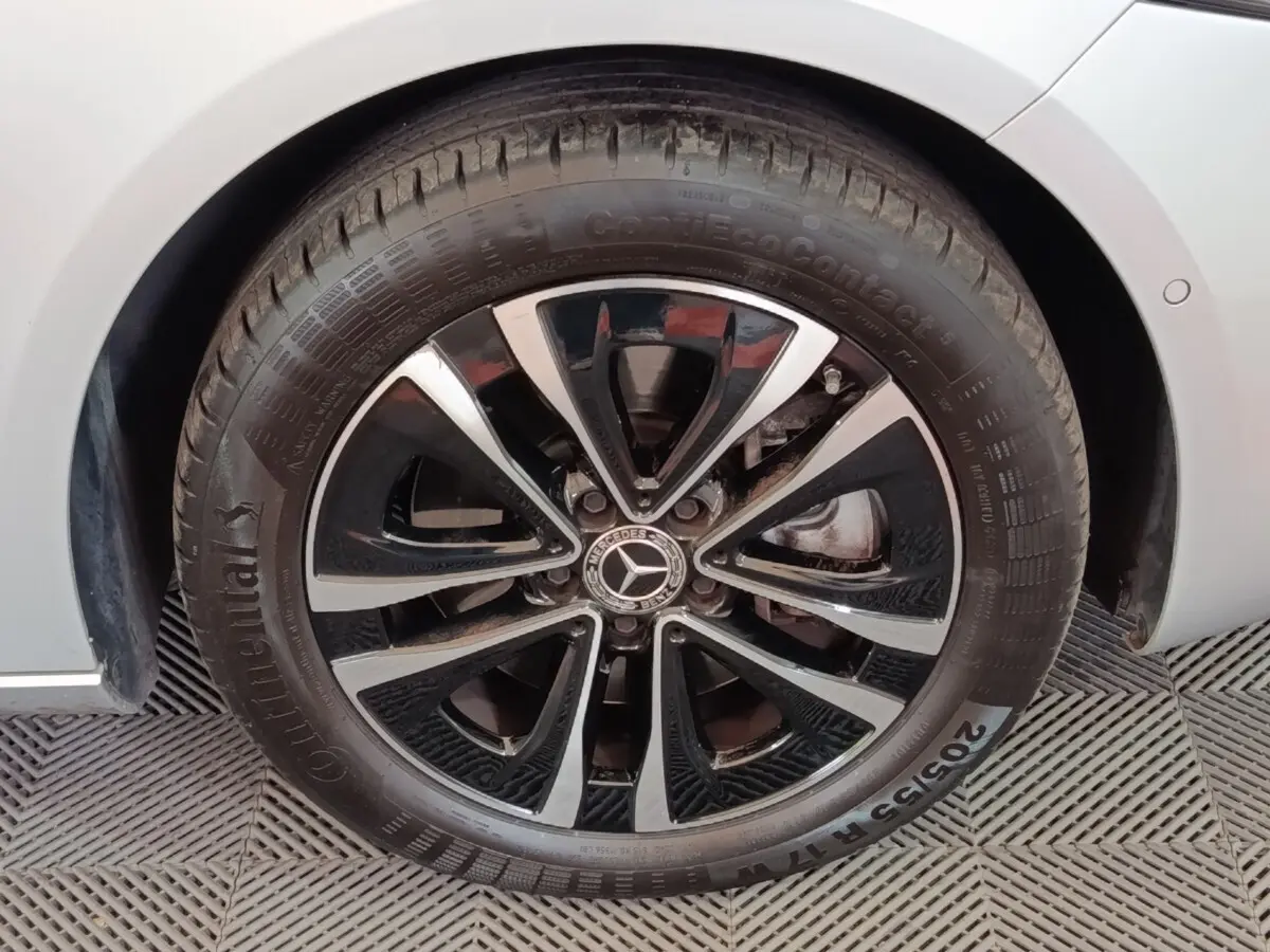 Gros plan sur la roue avant droite d'une Mercedes GLA 250 e gris foncé avec jante alliage noir et argentée.