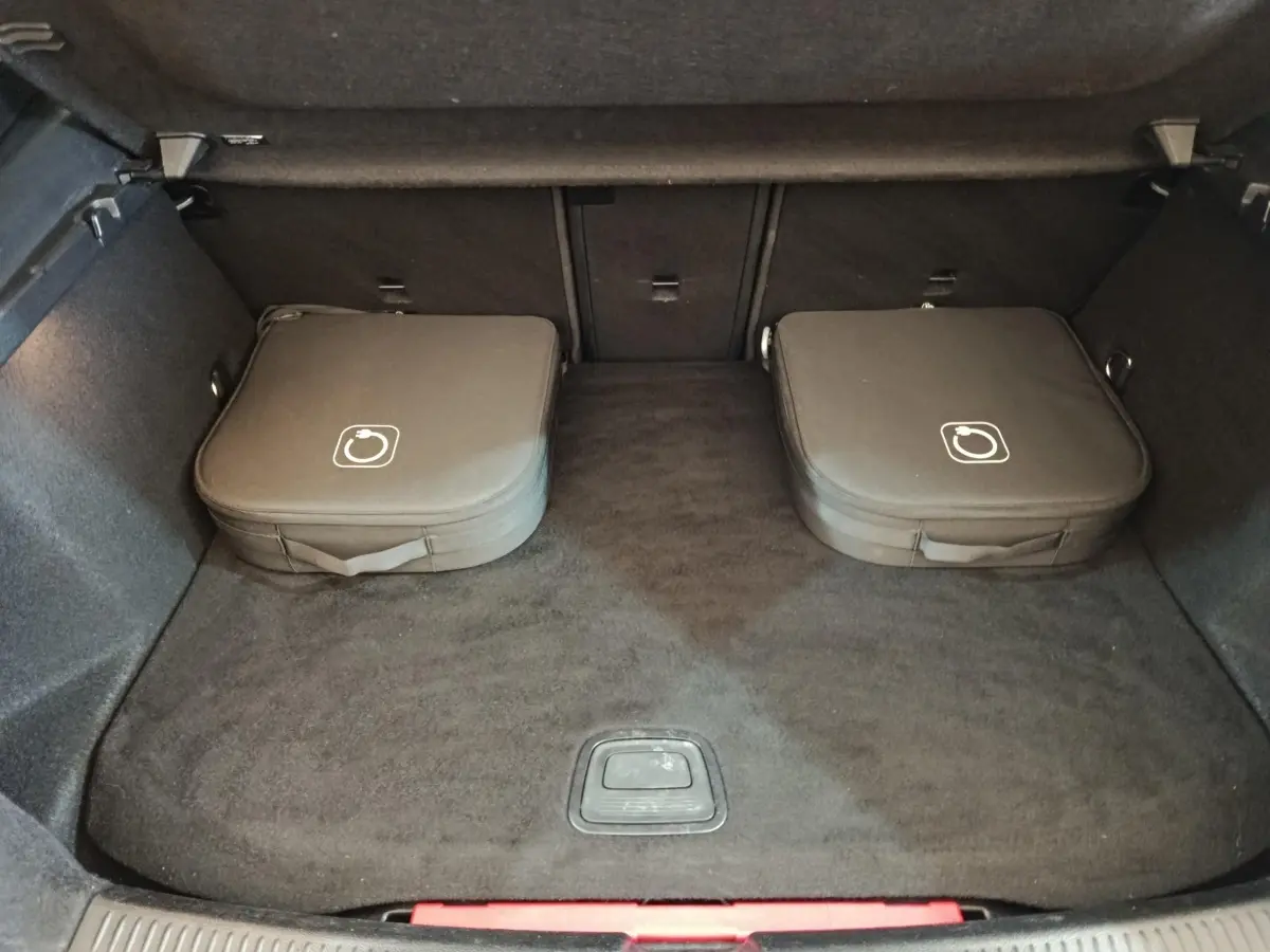 Coffre spacieux d’un Mercedes GLA 250 e Business Line gris foncé, avec deux sacs de rangement noirs posés à plat.